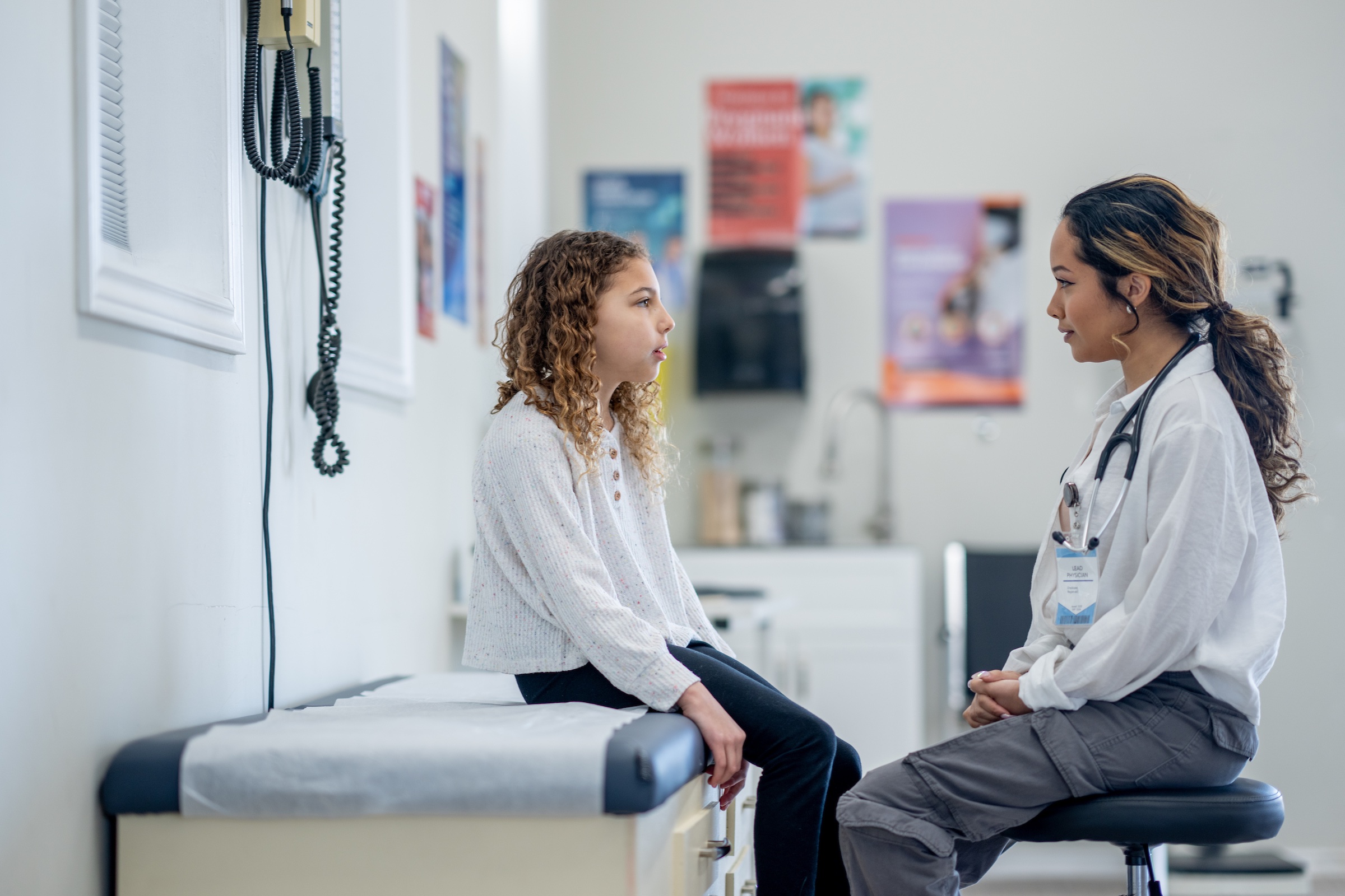 A child speaking with a clinician in an exam room
